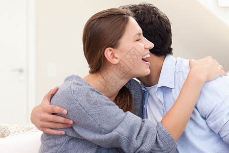 情侣相拥抱年轻人感情生活丈夫女性休息室相机长椅微笑房间图片