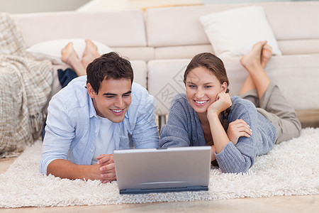 情侣用笔记本电脑看电影网络长椅已婚地毯女性妻子上网快乐沙发互联网图片
