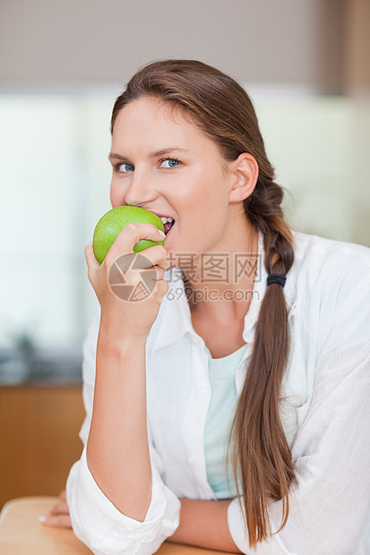 一位健康女人吃苹果的肖像图片