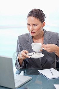 一位女商务人士喝咖啡的肖像图片