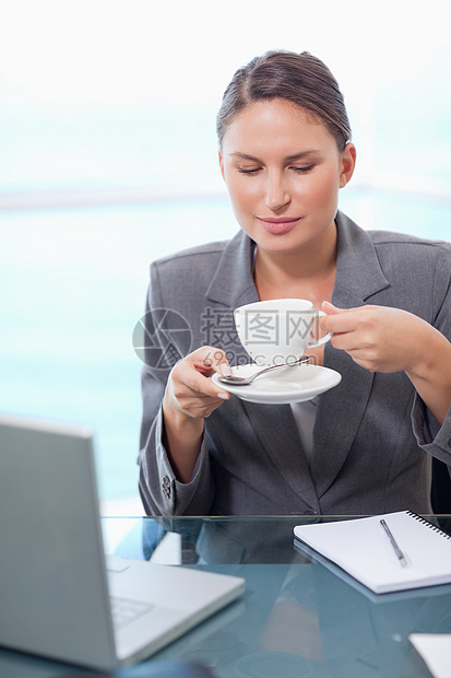 一位女商务人士喝茶的肖像图片
