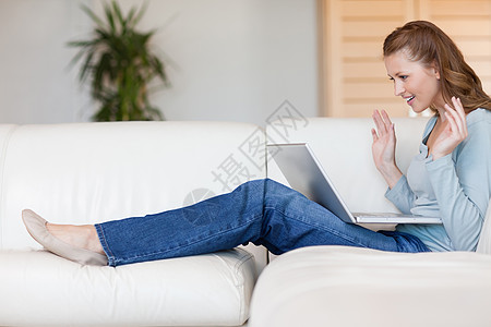 沙发上的年轻女青年 等着网上拍卖会结束背景图片