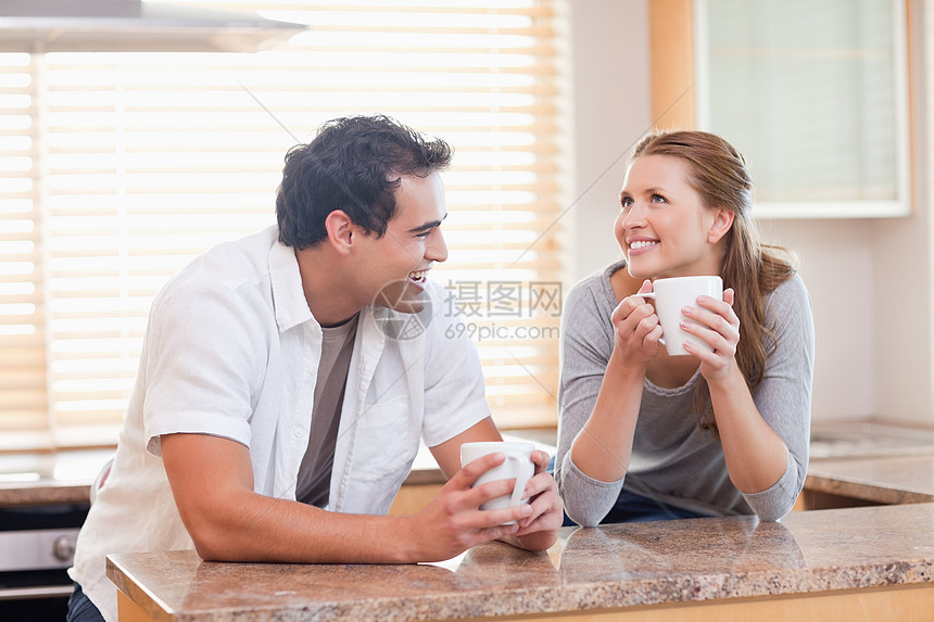 一起喝咖啡的一对幸福快乐的情侣享受牛奶早餐杯子女性咖啡桌子夫妻年轻人厨房图片