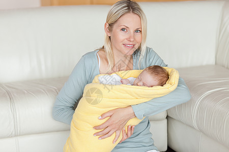 母亲坐在地上 怀着孩子在她的怀里图片