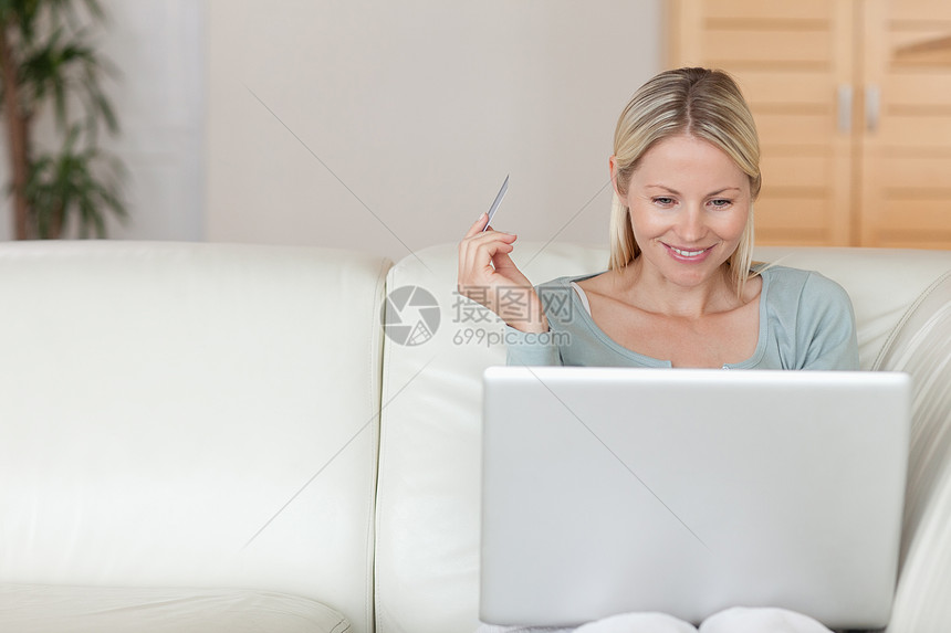妇女在线在沙发上购物互联网阅读女性闲暇快乐说谎成年冲浪外表电脑图片