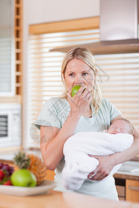 怀着婴儿的女婴在她的手臂上有一个苹果图片