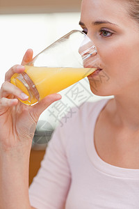 一个平静的女人喝果汁的肖像图片