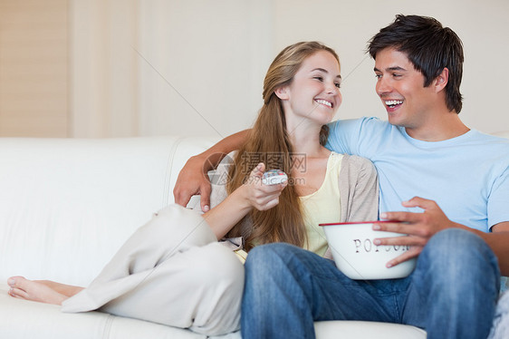 在吃爆米花时看电视的情侣图片