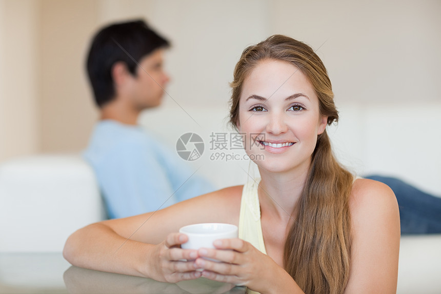 女人在未婚夫坐在沙发上时喝茶丈夫阅读快乐闲暇微笑友谊杯子已婚咖啡夫妻图片