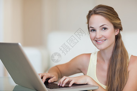 使用笔记本的年轻妇女沙发微笑生活长椅沟通互联网网络通讯女性幸福图片