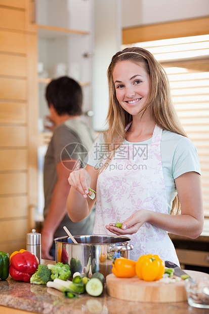 一个女人在未婚夫洗盘子时做饭的肖像图片