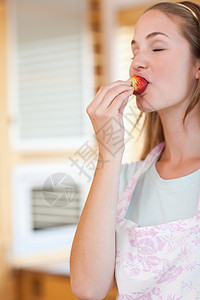 一个女人吃草莓的肖像乐趣幸福营养小吃浆果重量食物活力饮食水果图片