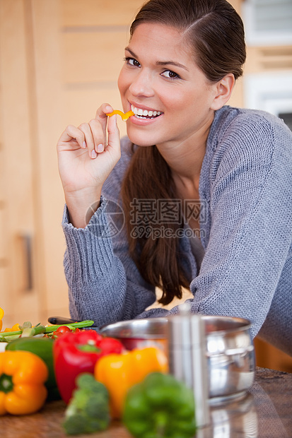 笑女人在厨房里吃胡椒粉图片