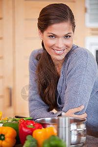 微笑的女人 靠在厨房柜台靠着图片