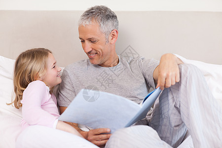 快乐的父亲读一个故事给女儿听图片