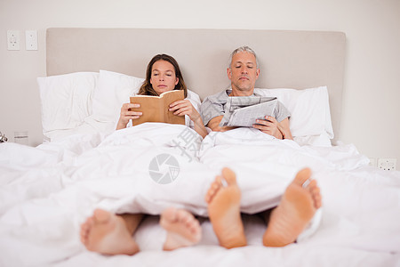 男人看新闻 而妻子在读一本书图片