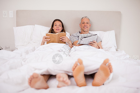 男人在看报纸 而妻子却在看书图片