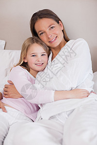 母亲和女儿抱抱的肖像亲热睡衣感情喜悦女孩们投标拥抱幸福家长童年图片