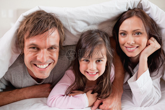 快乐的父母与女儿一起躺在女仆的下面图片