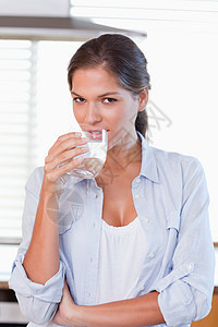 一位年轻女子喝杯水的肖像图片