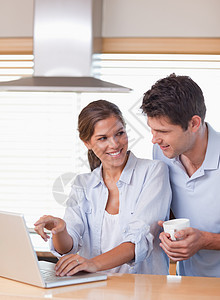喝茶时使用笔记本电脑的一对夫妇肖像厨房两个人沟通互联网男人杯子房子团结饮料夫妻图片