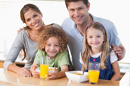 家人吃早餐快乐牛奶中年人兄弟姐妹果汁女士男生桌子父亲混血女孩图片
