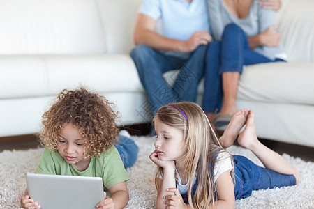 儿童使用平板电脑 而其父母在看孩子的父母图片
