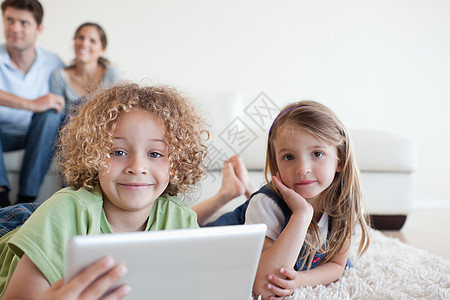 快乐的孩子使用平板电脑 而他们的父母却幸福图片