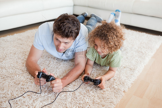 专注男孩和他父亲玩电子游戏图片