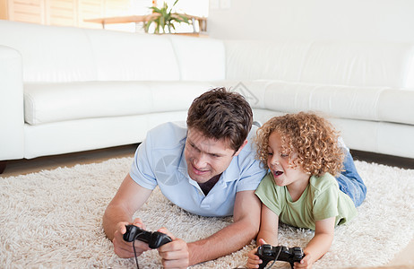 快乐的男孩和他父亲在玩电子游戏图片