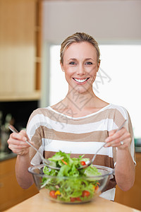 微笑的女人搅拌沙拉食物素食者准备美食晚餐维生素午餐蔬菜女士幸福图片