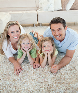 幸福的家庭在地板上兄弟姐妹孩子母亲四个人亲热男人乐趣中年人快乐儿子图片