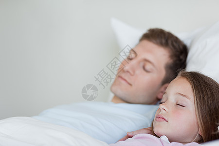 父亲和女儿睡着的侧视角图片