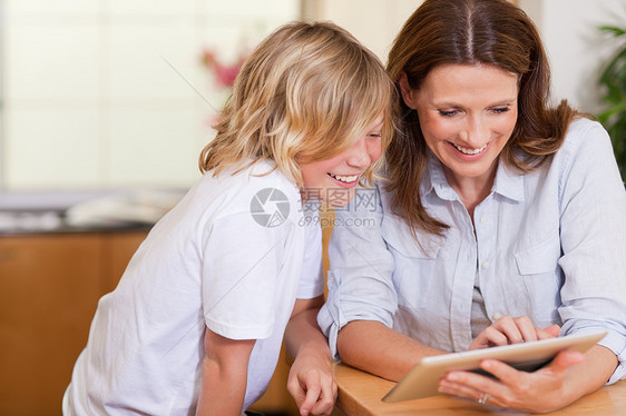 母亲和儿子使用平板药闲暇技术电子触摸屏幸福药片互联网团结软垫冲浪图片