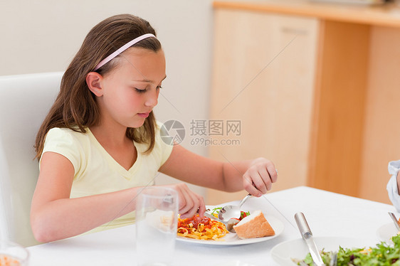 女孩在餐桌上吃晚饭快乐幸福庆典团结膳食食物沙拉孩子闲暇传统图片