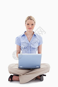 妇女坐在她的笔记本电脑上图片