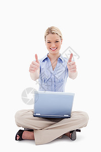 带笔记本电脑的坐着妇女举起拇指图片