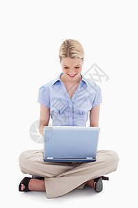 利用笔记本电脑工作的微笑的在座妇女图片
