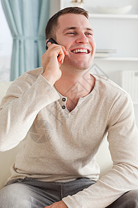 一个笑着的人坐在一边打个电话的肖像图片