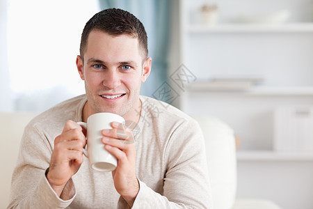 男人喝咖啡咖啡房间享受外表年轻人沙发幸福白色微笑牛奶图片