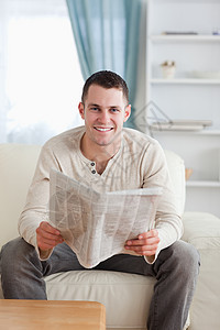 一个带着报纸的微笑的男人的肖像图片