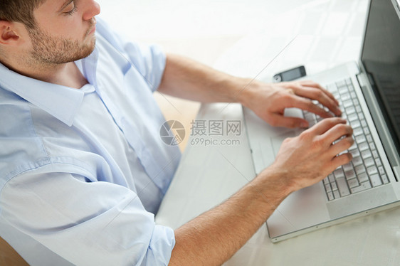 膝上型电脑上的商务打字笔记本人士电话讯息短信工人手机邮件商业网络图片