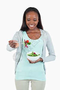 有沙拉在叉子上的年轻女人图片