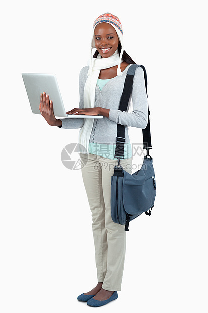 冬季服装和笔记本电脑对女学生的侧视图片
