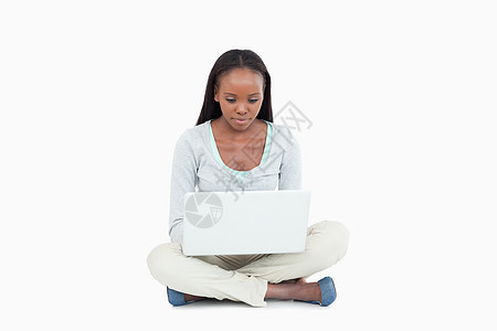 年轻女士用笔记本电脑坐在地上图片