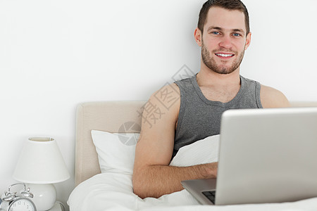 年轻人使用笔记本电脑快乐乐趣沟通幸福互联网网络工作卧室技术微笑图片