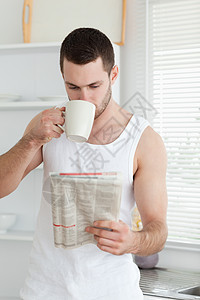 一名男子在看新闻时喝茶的肖像图片