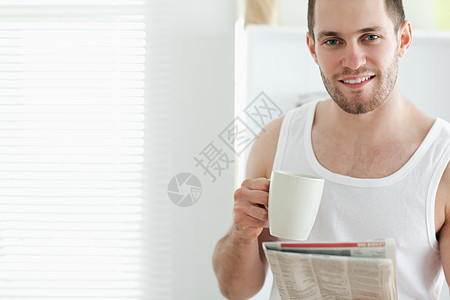 好帅的男人在看新闻时喝着茶图片