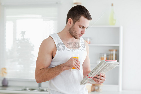 男人在看新闻时喝橙汁图片