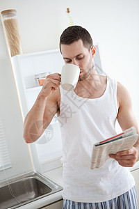一个帅气的男人的肖像 一边喝茶 一边看书图片